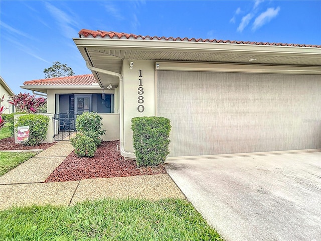 property entrance featuring driveway, a tiled roof, and stucco siding