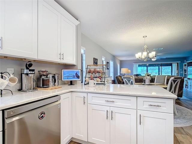 kitchen featuring a chandelier, a peninsula, open floor plan, stainless steel dishwasher, and light wood-type flooring