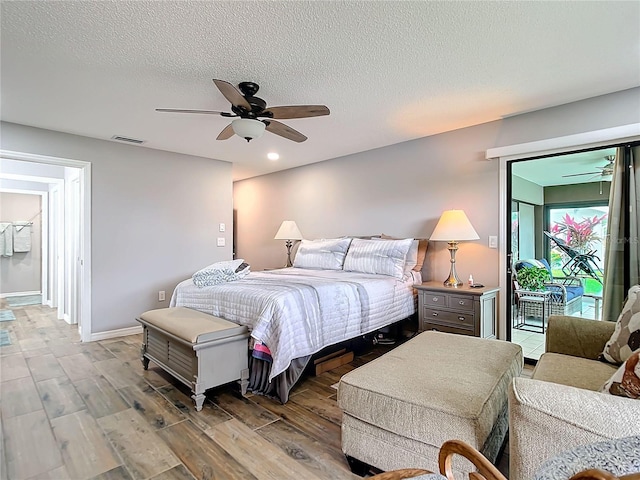 bedroom featuring access to outside, visible vents, ceiling fan, a textured ceiling, and light wood-type flooring