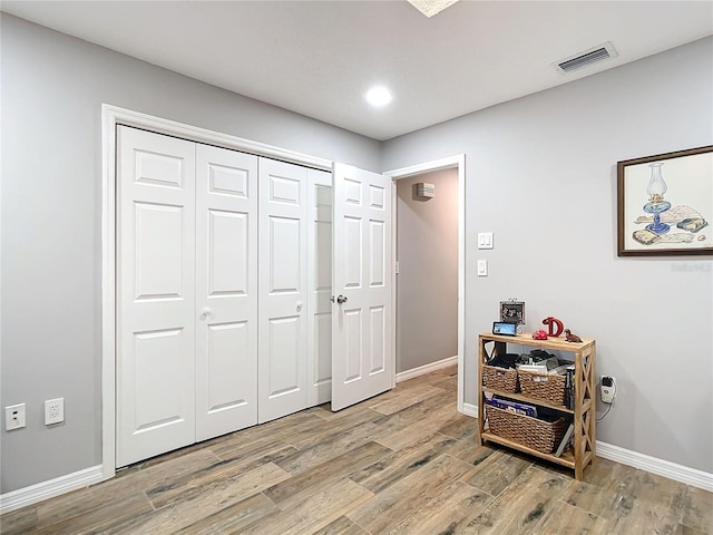 interior space featuring light wood-style flooring, visible vents, and baseboards