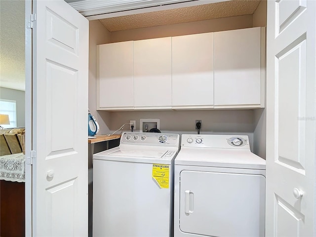 laundry area featuring a textured ceiling, independent washer and dryer, and cabinet space