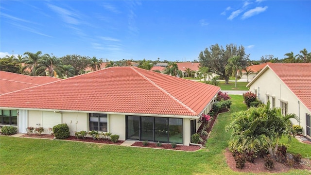 back of house with a lawn and a tiled roof