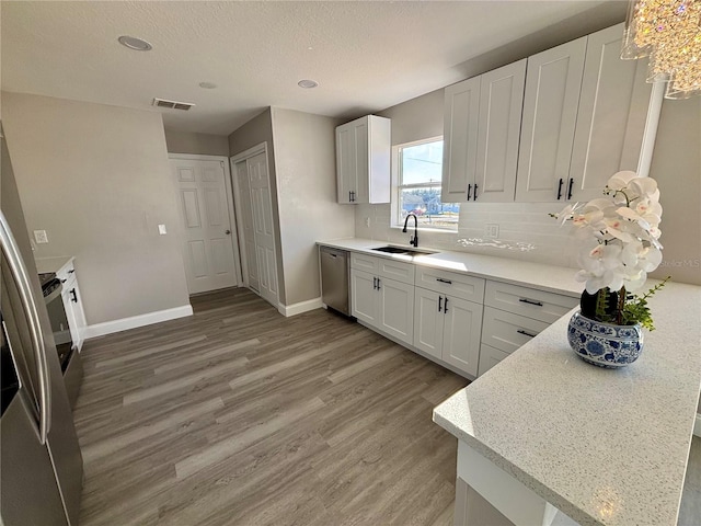 kitchen with white cabinetry, stainless steel dishwasher, and sink