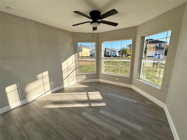 unfurnished room featuring ceiling fan and dark wood-type flooring