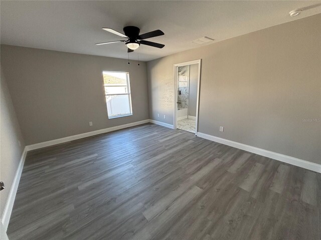 spare room featuring ceiling fan and dark wood-type flooring