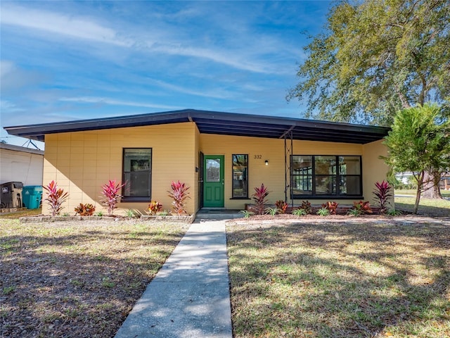 view of front facade with a carport and a front lawn