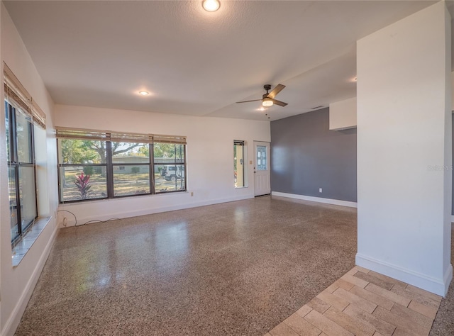 unfurnished room with ceiling fan and a textured ceiling