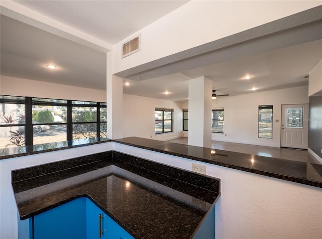 interior space featuring dark stone counters and ceiling fan