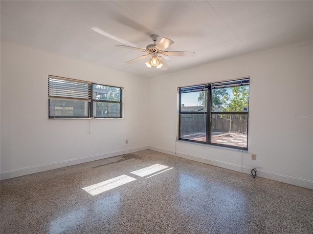 spare room featuring ceiling fan and a wealth of natural light