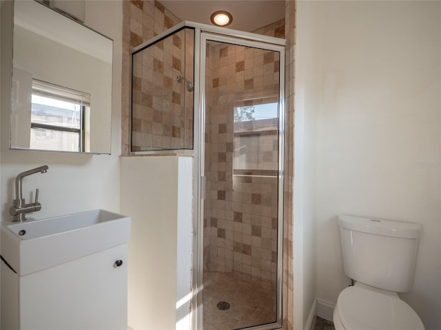 bathroom with a shower with door, vanity, and toilet