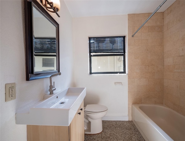 full bathroom featuring toilet, vanity, and tiled shower / bath