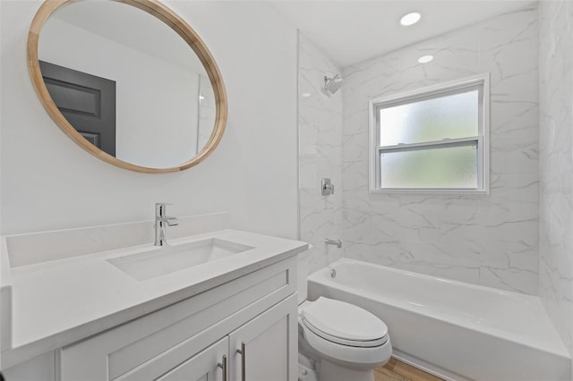 full bathroom featuring hardwood / wood-style floors, vanity, toilet, and tiled shower / bath