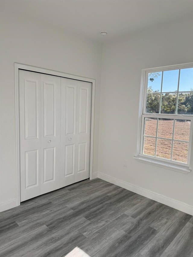 unfurnished bedroom featuring a closet and dark hardwood / wood-style floors