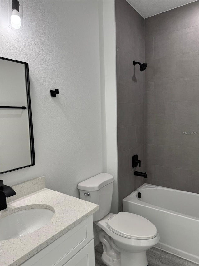 full bathroom with toilet, vanity, wood-type flooring, shower / bath combination, and a textured ceiling