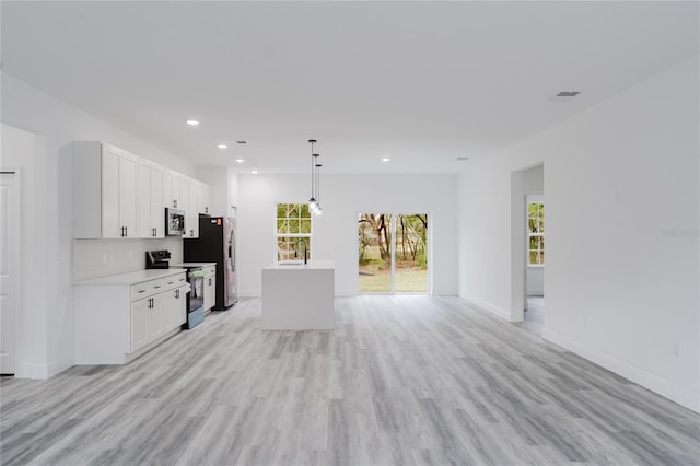 kitchen featuring appliances with stainless steel finishes, light hardwood / wood-style flooring, pendant lighting, and white cabinets