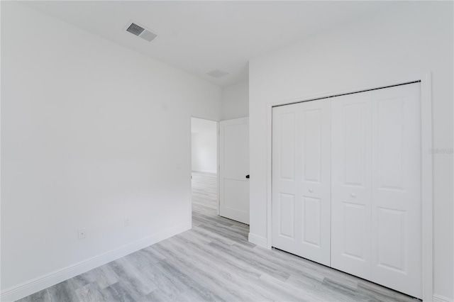 unfurnished bedroom featuring light hardwood / wood-style flooring and a closet