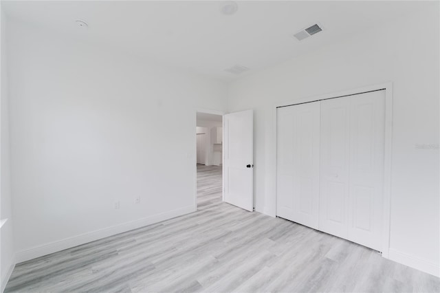 unfurnished bedroom featuring light wood-type flooring and a closet