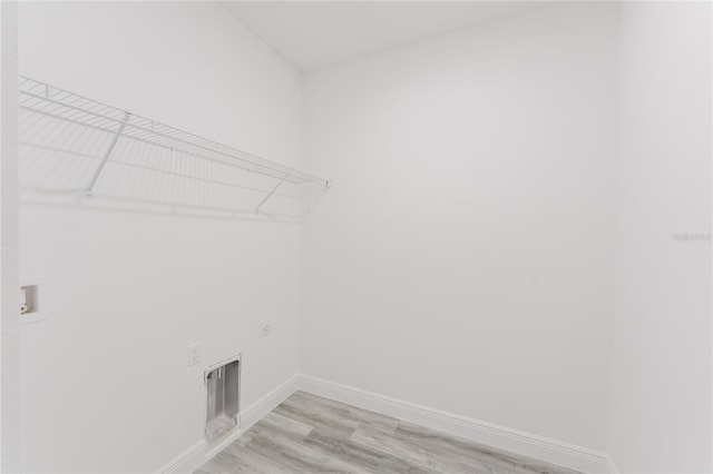 clothes washing area with light wood-type flooring, hookup for a washing machine, and electric dryer hookup