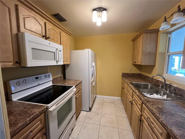 kitchen featuring sink, light tile patterned floors, and white appliances