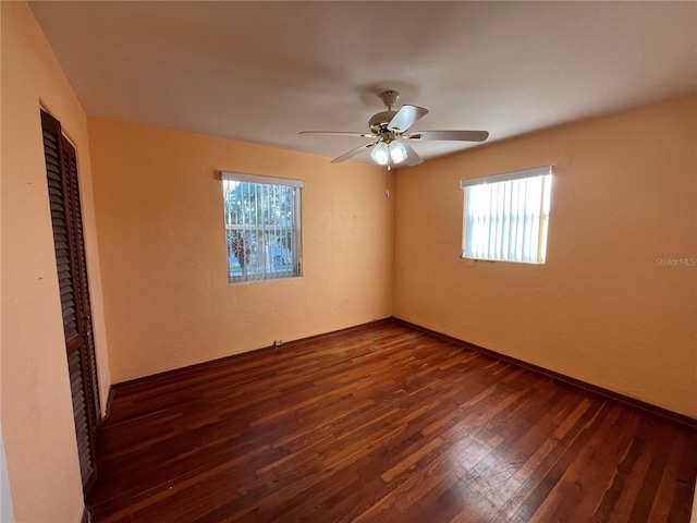 unfurnished room with dark hardwood / wood-style floors, ceiling fan, and a wealth of natural light