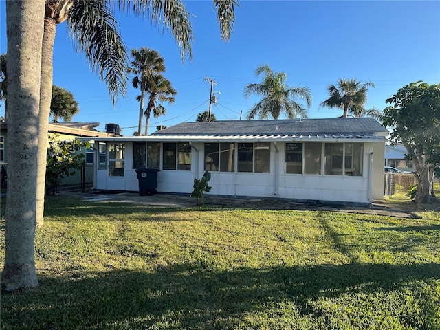 rear view of house featuring a lawn