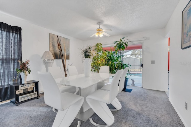 carpeted dining room featuring a textured ceiling and ceiling fan