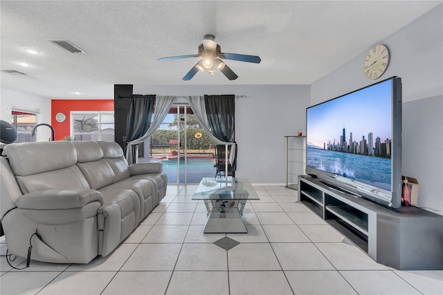 tiled living room with ceiling fan and a textured ceiling