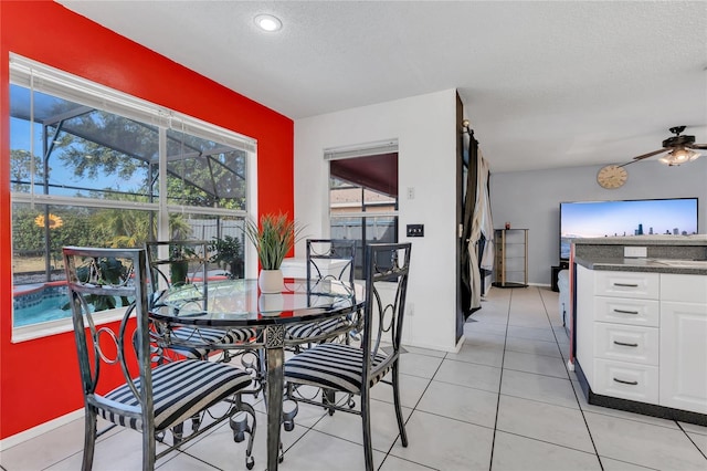 tiled dining space featuring ceiling fan and a textured ceiling