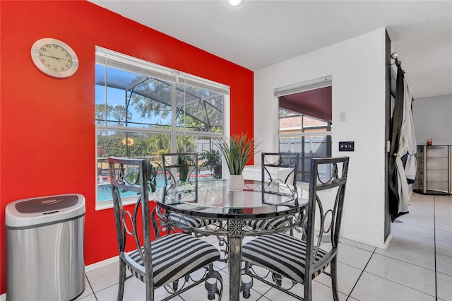 dining area with a textured ceiling and light tile patterned flooring