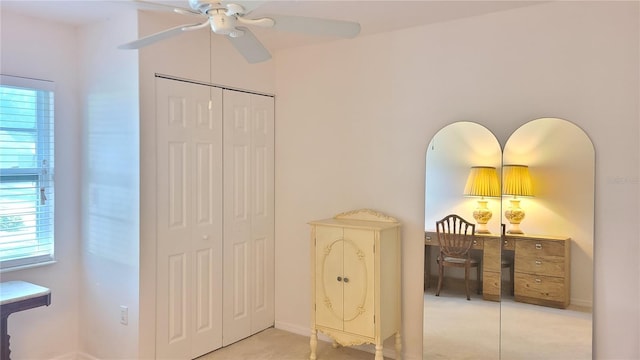 interior space featuring light carpet, a closet, and ceiling fan