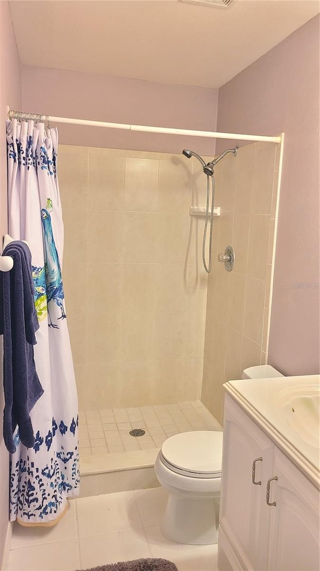 bathroom featuring tile patterned floors, vanity, curtained shower, and toilet