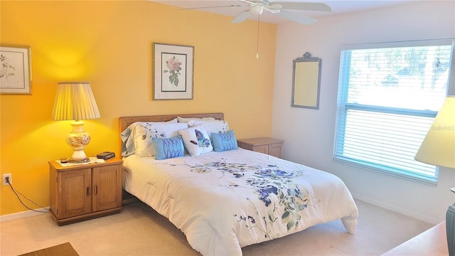 bedroom with multiple windows, ceiling fan, and light colored carpet