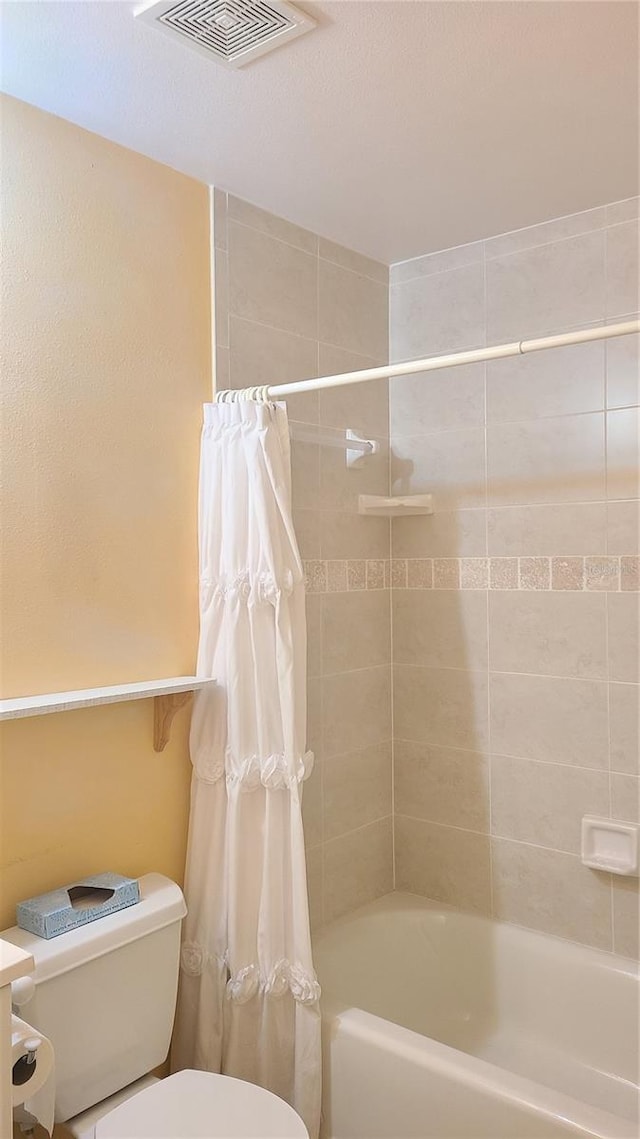 bathroom with shower / bath combo and toilet