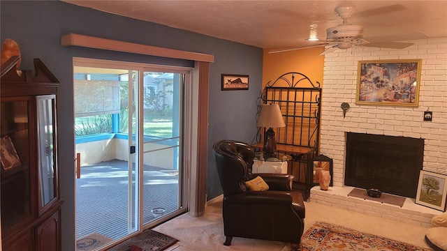 carpeted living room with ceiling fan and a fireplace