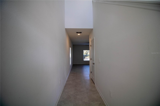 corridor with tile patterned floors and a high ceiling