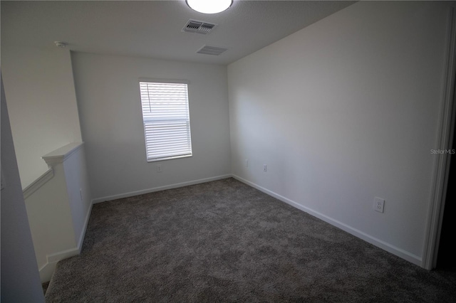 unfurnished room featuring dark colored carpet