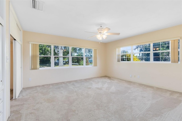 carpeted empty room featuring ceiling fan