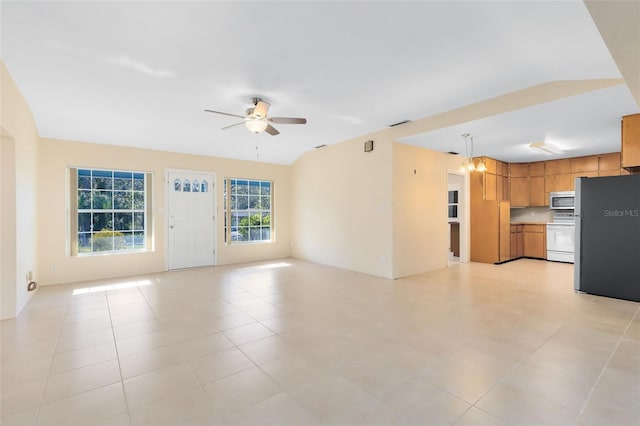 unfurnished living room featuring ceiling fan with notable chandelier and light tile patterned floors