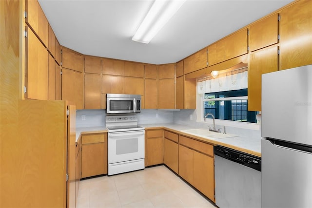 kitchen featuring appliances with stainless steel finishes, sink, and light tile patterned floors