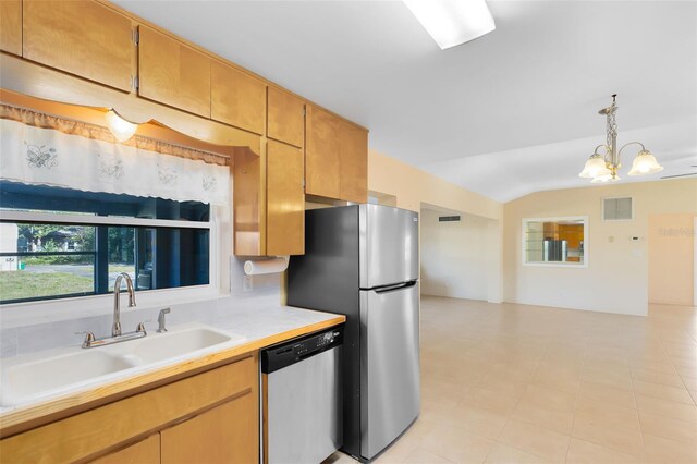 kitchen with appliances with stainless steel finishes, pendant lighting, an inviting chandelier, and sink