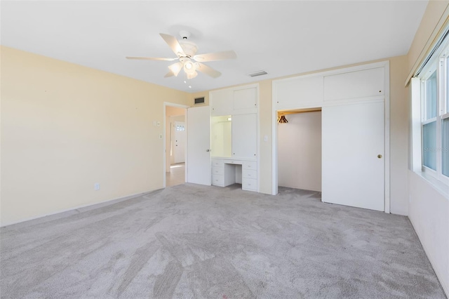 unfurnished bedroom with a closet, ceiling fan, and light colored carpet