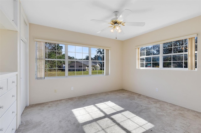 unfurnished room featuring light colored carpet and ceiling fan