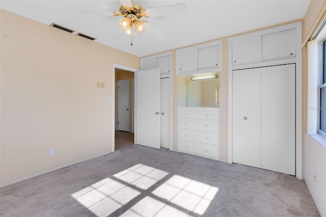 unfurnished bedroom with ceiling fan, a closet, and light carpet