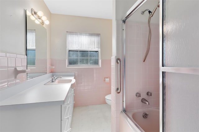 full bathroom featuring tile walls, toilet, vanity, and tiled shower / bath