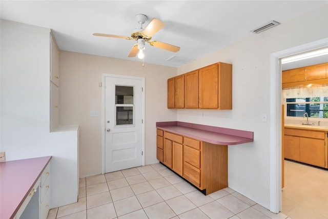 kitchen featuring sink, ceiling fan, and light tile patterned flooring