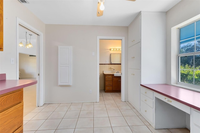 interior space featuring tile patterned floors, a chandelier, and vanity