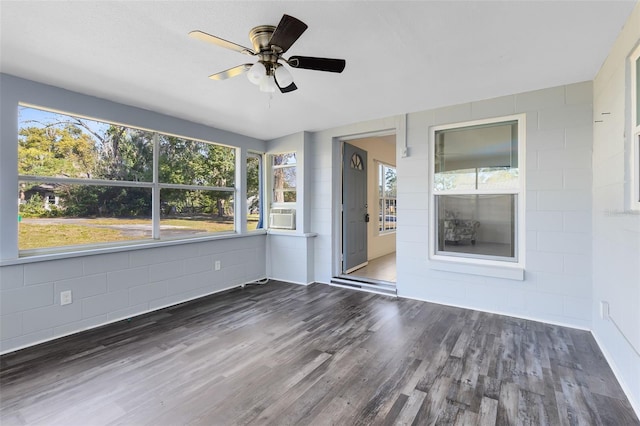 unfurnished sunroom with ceiling fan