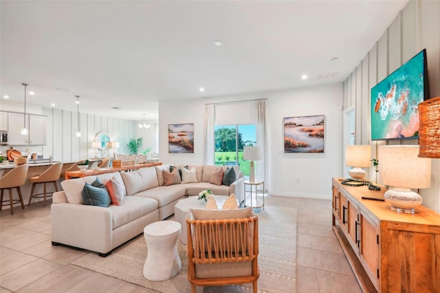 living room with light tile patterned floors and an inviting chandelier