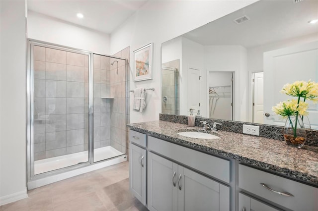 bathroom with tile patterned floors, vanity, and walk in shower