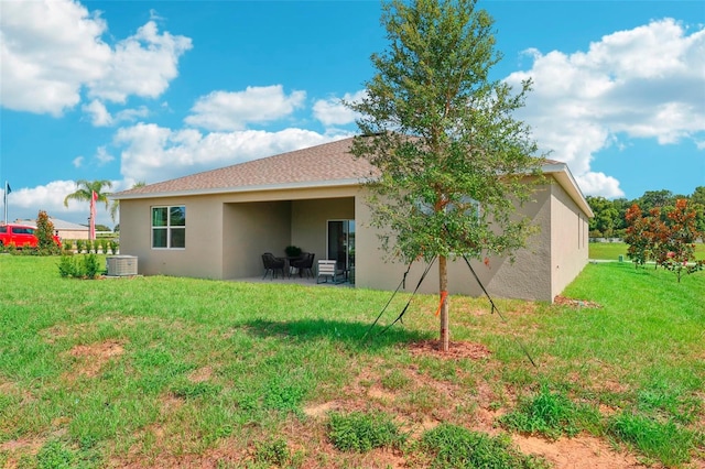 back of house with central AC and a lawn